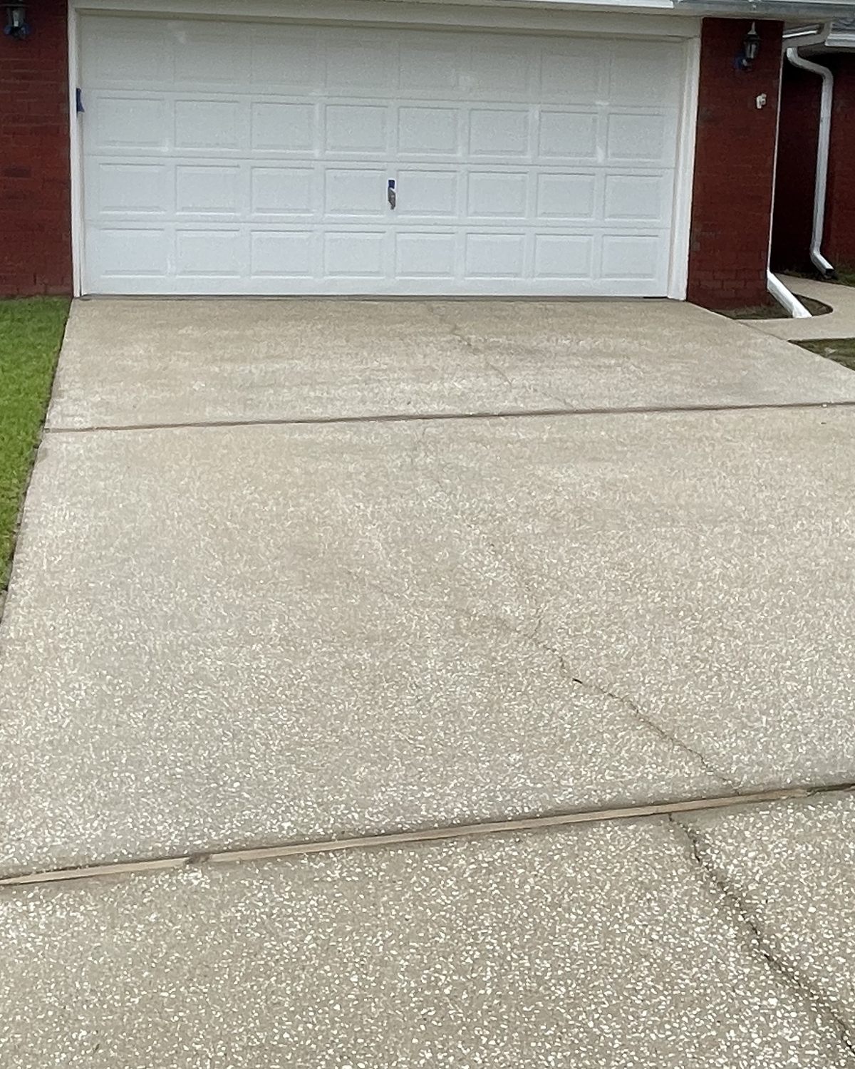 The same driveway after cleaning, light and even in front of the white garage door