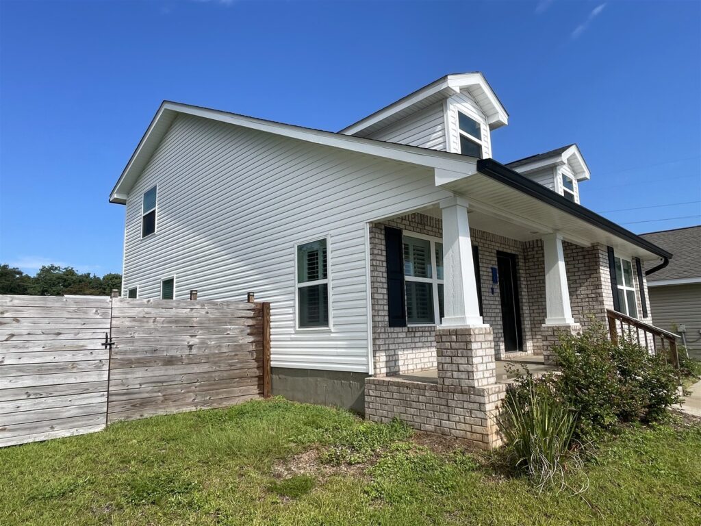 The side and front porch of the same house, with clean white siding and fresh-looking trim